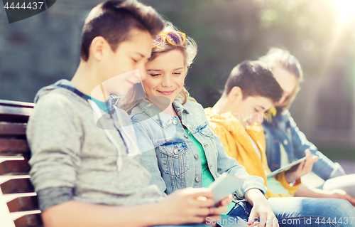 Image of happy teenage friends with tablet pc outdoors