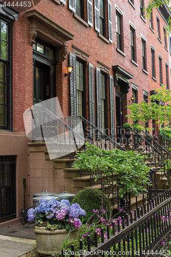 Image of Row of old brownstone buildings along an empty sidewalk block in the Greenwich Village neighborhood of Manhattan, New York City NYC