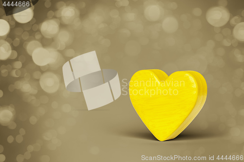 Image of A yellow wooden heart in a bokeh lights background