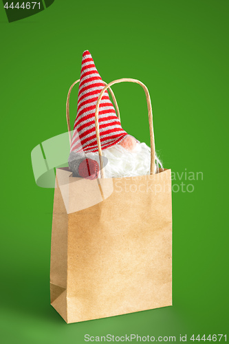 Image of christmas gnome in a paper bag isolated on green background