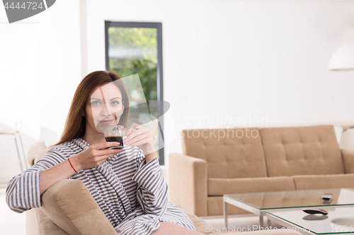 Image of young woman in a bathrobe enjoying morning coffee