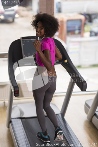 Image of afro american woman running on a treadmill