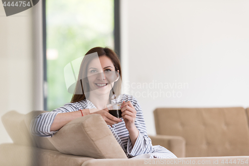 Image of young woman in a bathrobe enjoying morning coffee