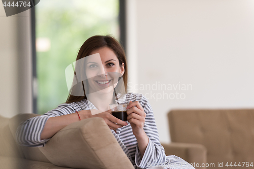 Image of young woman in a bathrobe enjoying morning coffee