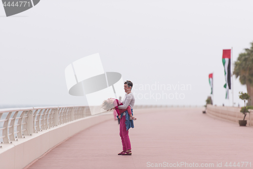 Image of mother and cute little girl on the promenade by the sea