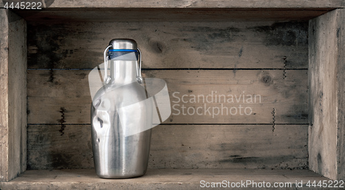 Image of old dented metal bottle on wooden background