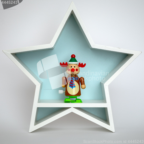 Image of Christmas decoration white star with funny reindeer figure insid