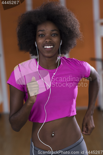 Image of afro american woman running on a treadmill