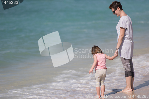 Image of mother and daughter running on the beach