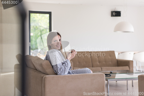 Image of young woman in a bathrobe enjoying morning coffee