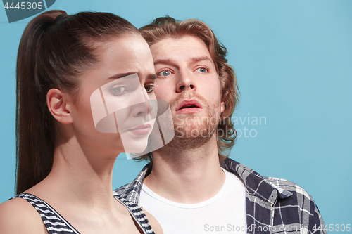 Image of Depressed couple. Depressed young couple standing close to each other while isolated on bue