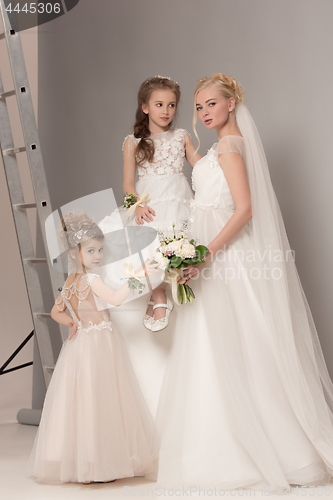 Image of Little pretty girls with flowers dressed in wedding dresses