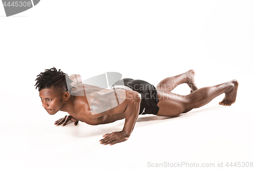 Image of Muscular young man doing press-ups