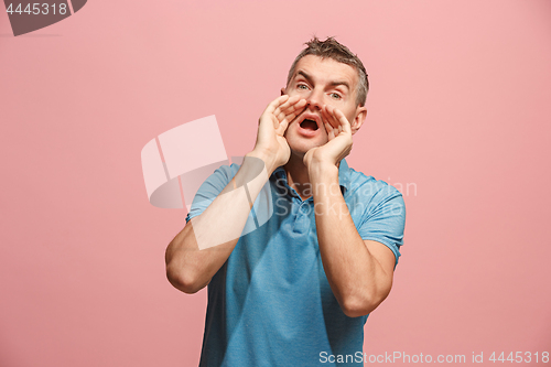 Image of Isolated on pink young casual man shouting at studio