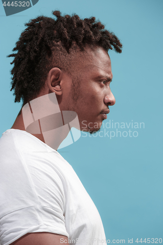 Image of The young emotional angry afro man on blue studio background