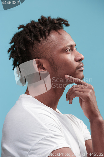 Image of Let me think. Doubtful pensive Afro-American man with thoughtful expression making choice against blue background