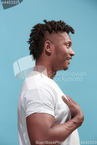 Image of The surprised business Afro-American man standing and looking blue background. Profile view.