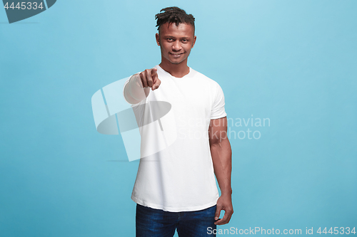 Image of The happy afro-american businessman point you and want you, half length closeup portrait on blue background.