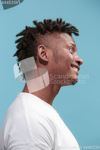 Image of The crazy business Afro-American man standing and wrinkle face blue background. Profile view.