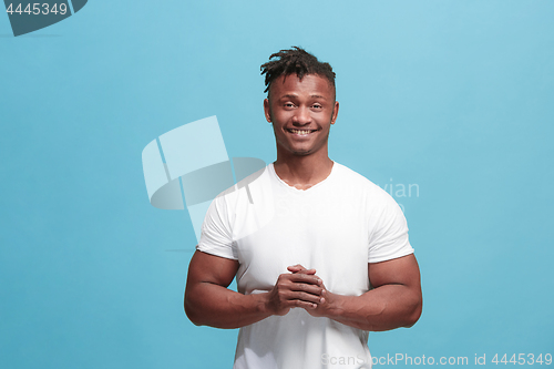 Image of The happy afro-american business man standing and smiling against blue background.