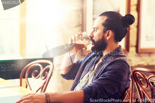 Image of happy man drinking beer at bar or pub