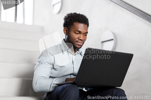 Image of african american businessman with laptop at office