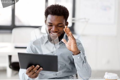 Image of businessman having video chat on tablet at office