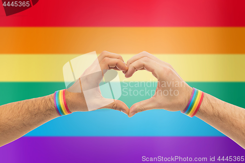 Image of male hands with gay pride wristbands showing heart