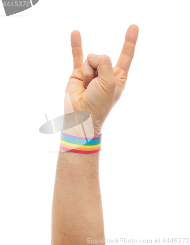 Image of hand with gay pride rainbow wristband shows rock