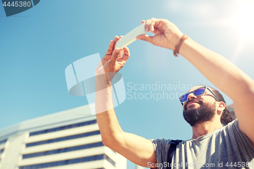 Image of man taking video or selfie by smartphone in city