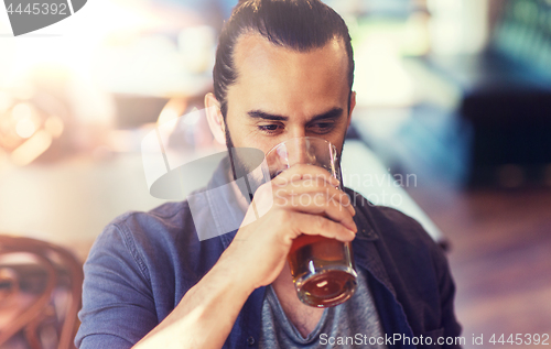 Image of happy man drinking beer at bar or pub