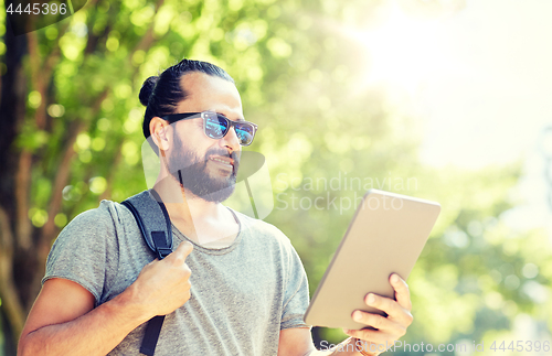 Image of man traveling with backpack and tablet pc in city