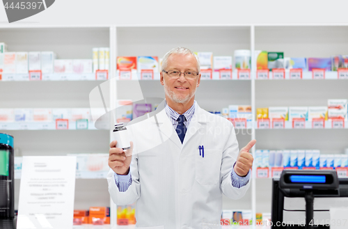 Image of senior apothecary with drug at pharmacy