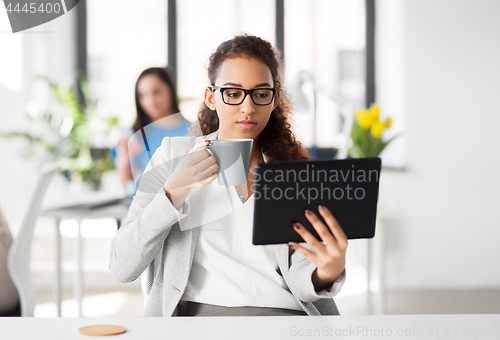 Image of businesswoman with tablet pc and coffee at office