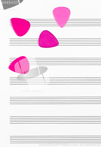 Image of Crimson guitar picks on empty sheet music paper