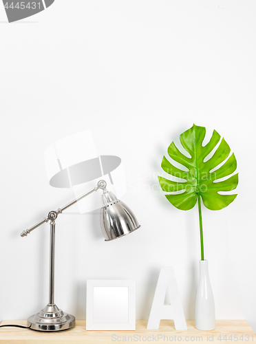 Image of Elegant home decor with metal lamp and tropical leaf