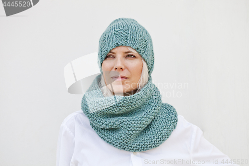 Image of Woman in warm turquoise knitted hat and snood.