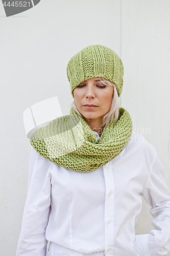 Image of Woman in warm green knitted hat and snood.