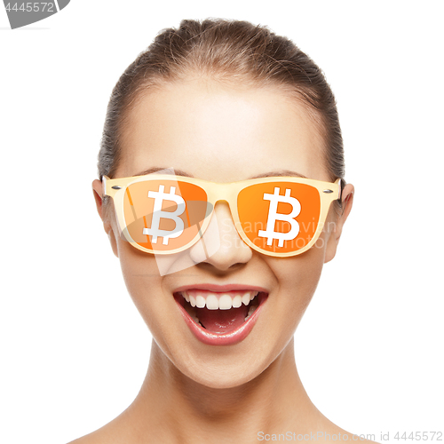 Image of happy girl in glasses with bitcoin signs