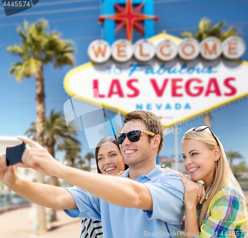 Image of group of happy friends taking selfie by cell phone