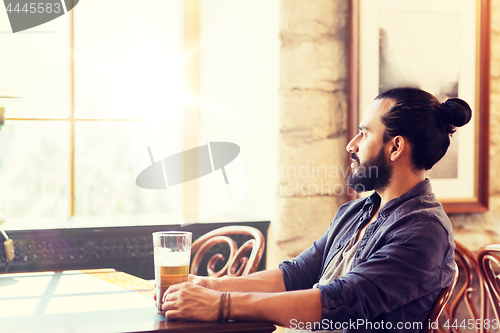 Image of happy man drinking beer at bar or pub