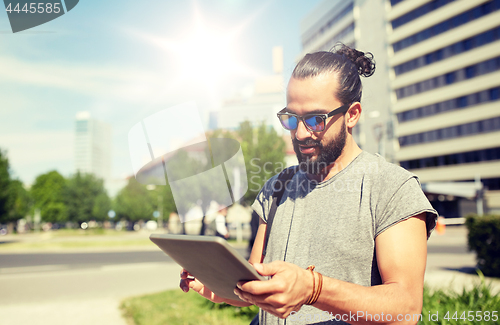 Image of man traveling with backpack and tablet pc in city