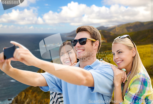 Image of group of happy friends taking selfie by cell phone