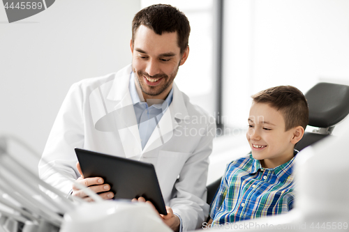 Image of dentist showing tablet pc to kid patient at clinic
