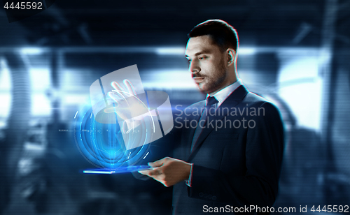 Image of businessman with transparent tablet and hologram