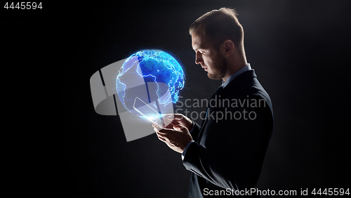 Image of businessman with tablet pc and earth hologram