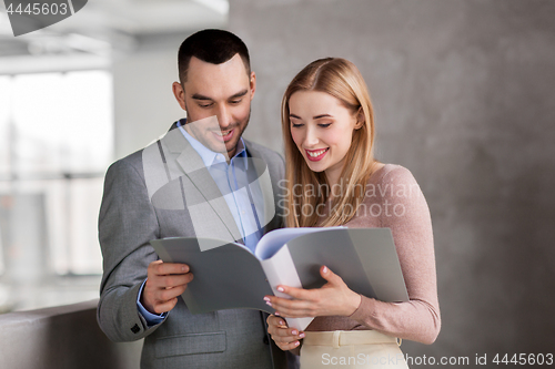 Image of businesswoman and businessman with folder