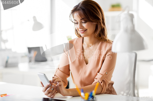 Image of businesswoman with smartphone working at office