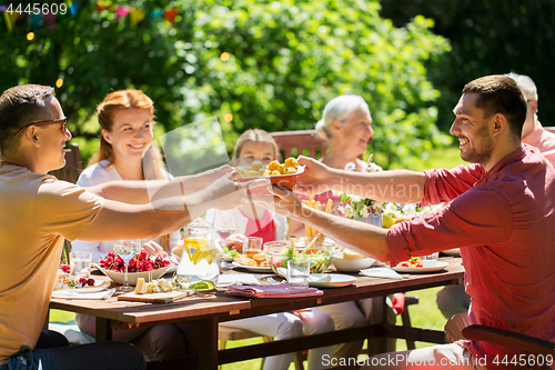Image of happy family having dinner or summer garden party