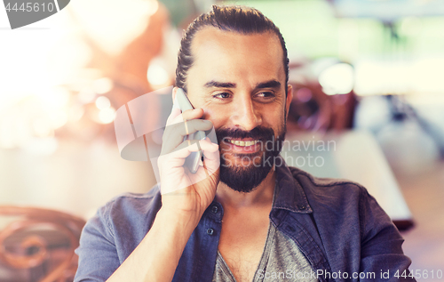 Image of happy man calling on smartphone at bar or pub